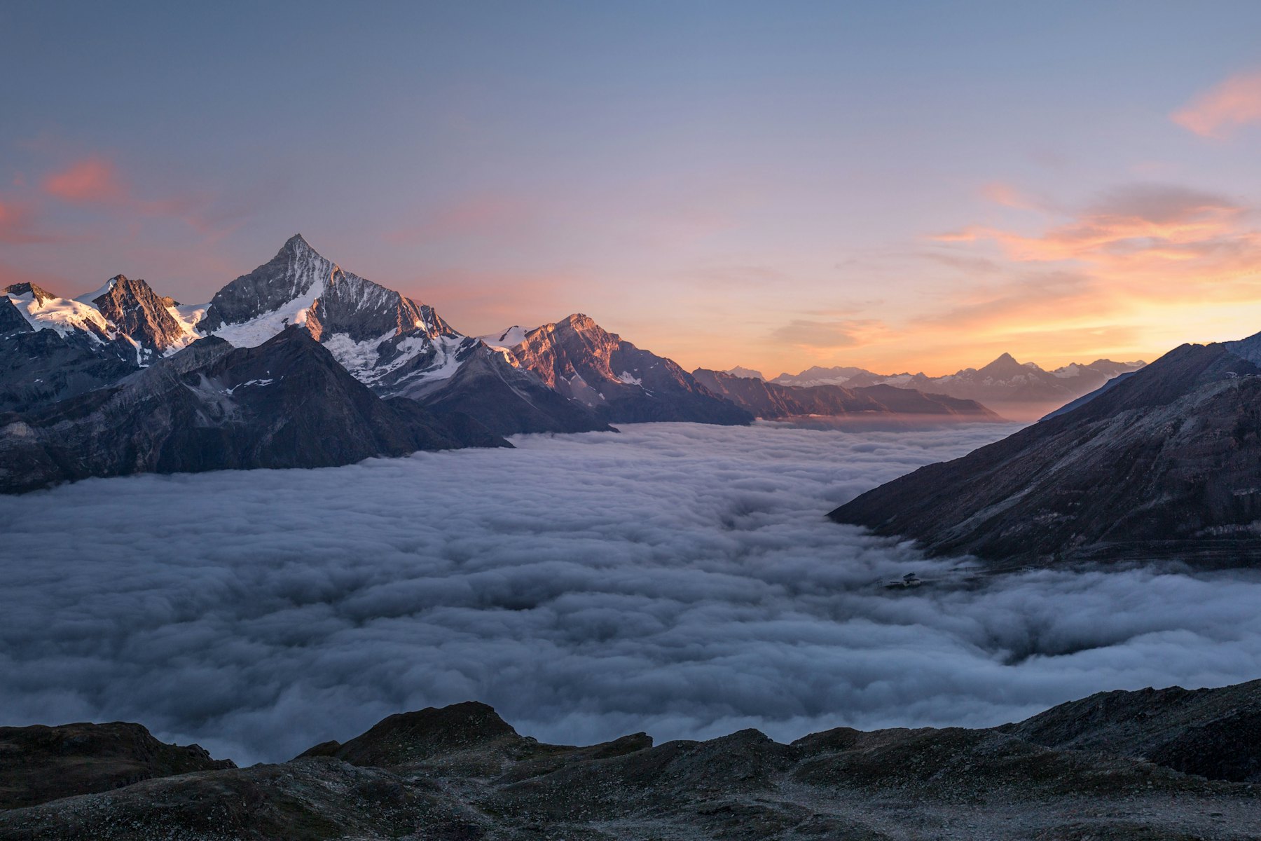 Himalayan peaks rising above a sea of clouds at dawn