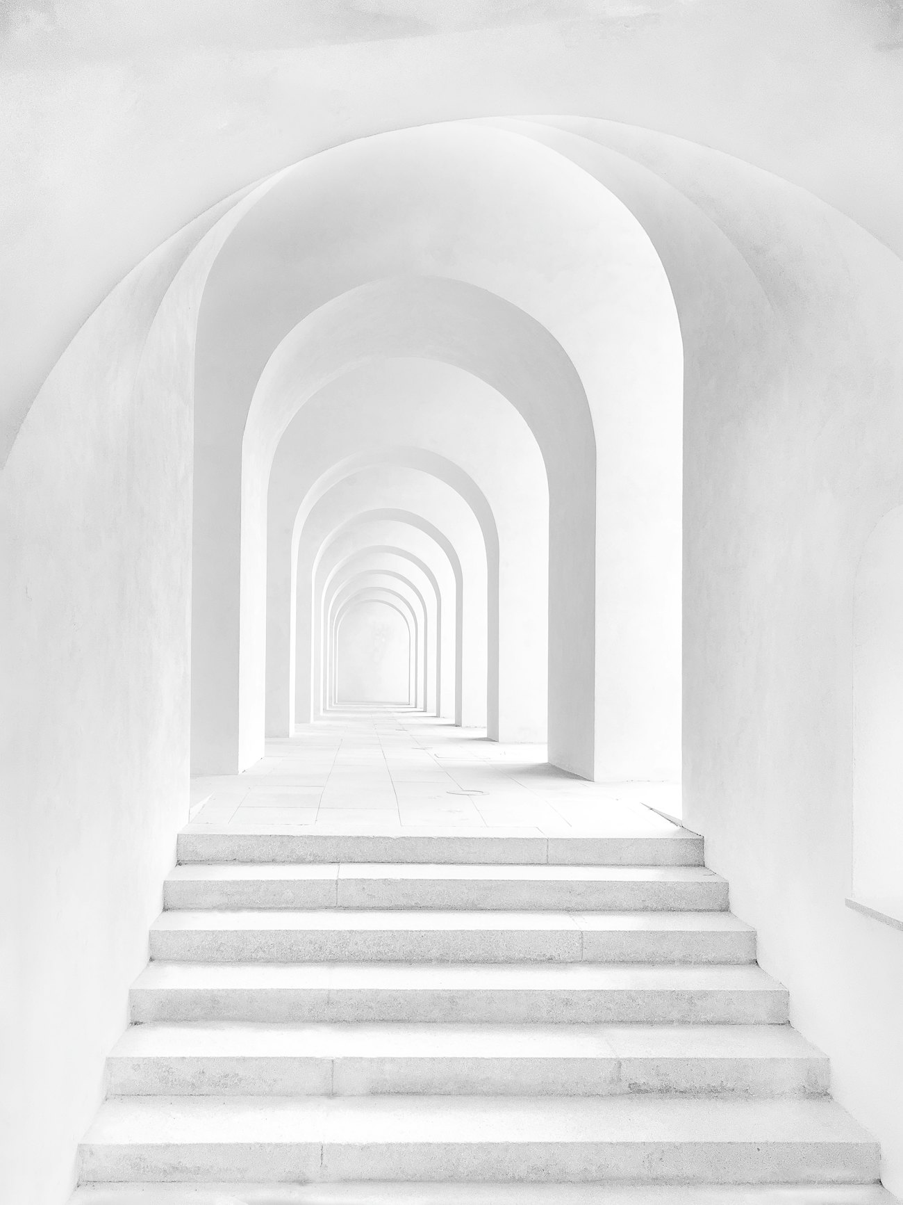 A corridor of white arches