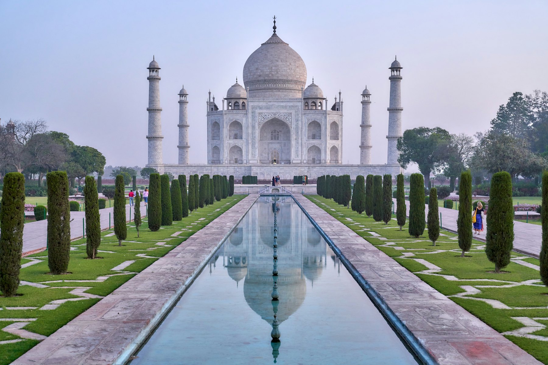 The Taj Mahal reflected in its long pool at dawn
